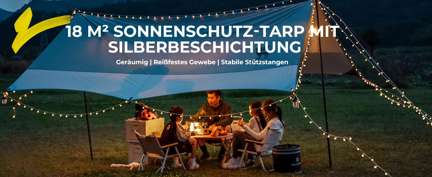 grosse camping tarp bei nacht mit familie und lichterkette im freien
