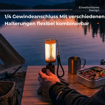 kleine campinglampe montiert auf stativ am see bei sonnenuntergang