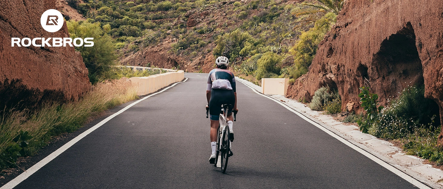 rennradfahrer auf einer bergstrasse mit der fahrradtasche im einsatz
