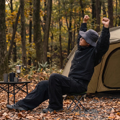 mann sitzt auf klapphocker beim camping im wald