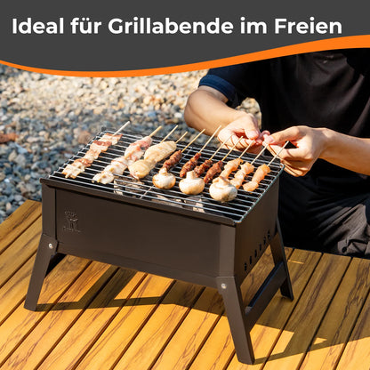 grillen von spießen und pilzen mit dem tragbaren grill draußen