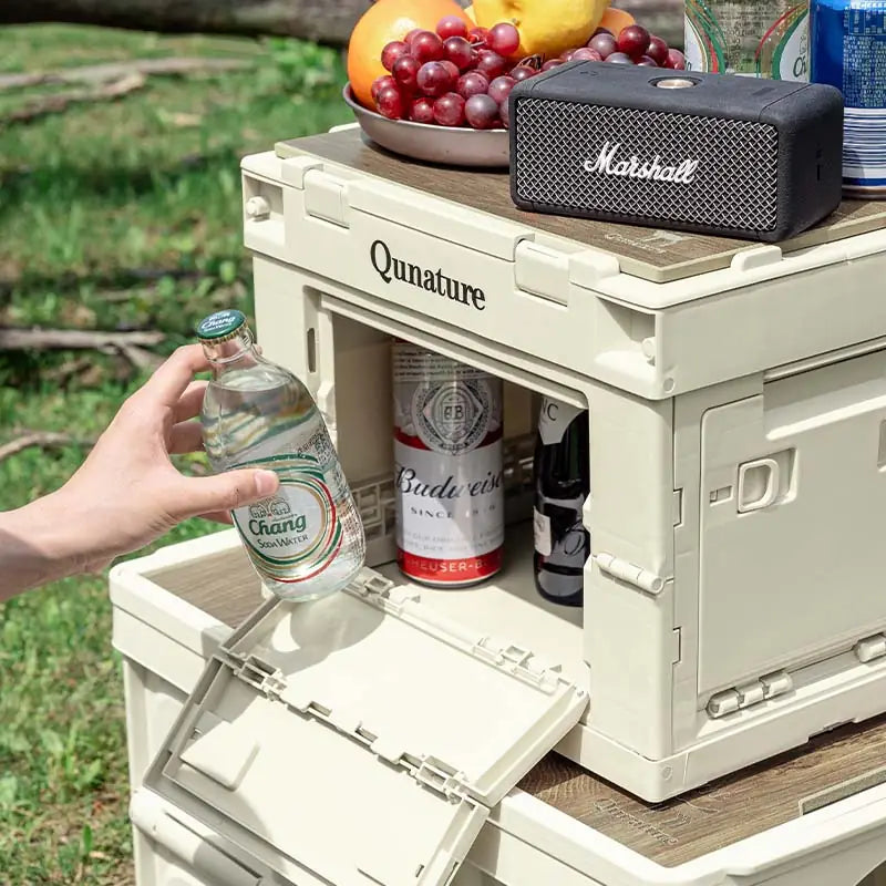 hand zieht mineralwasserflasche aus der geöffneten seitenklappe der aufbewahrungsbox
