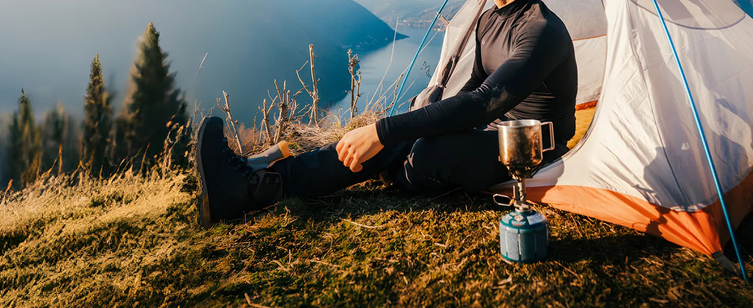 isomatte camping szene mann sitzt vor zelt am bergsee