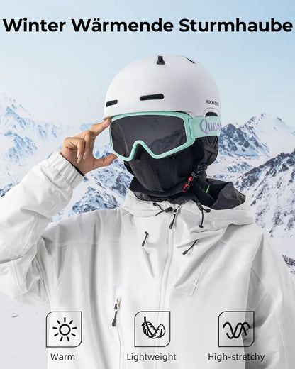 eine skifahrerin in weisser jacke nutzt die schwarze sturmhaube als k?lteschutz.