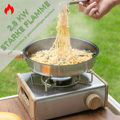 cooking noodles in a pan on a camping gas stove with blue flame outdoors
