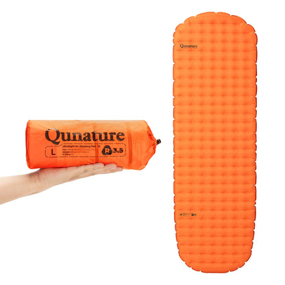 orange aufblasbare isomatte in der hand und ausgebreitet