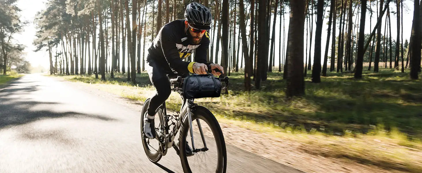 radfahrer auf einem straßenrad mit einer lenkertasche in natur