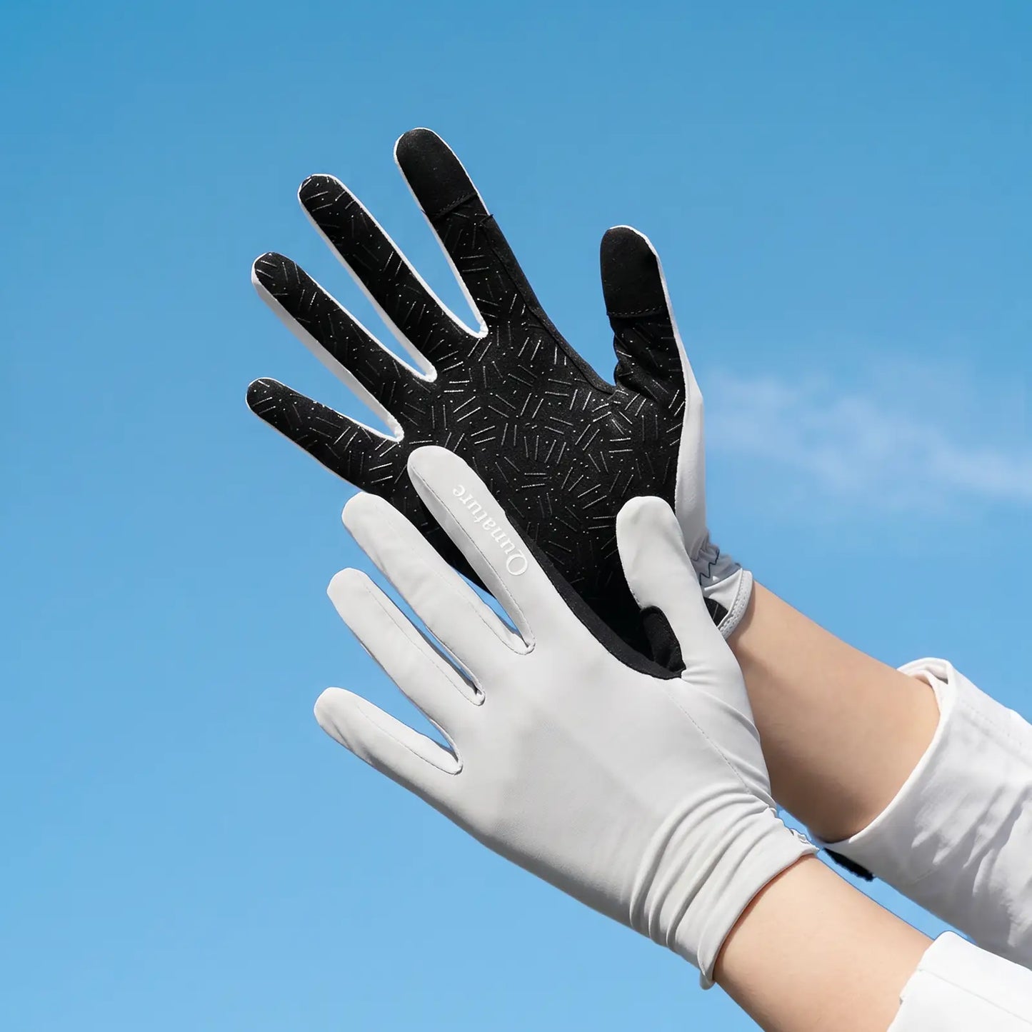 paar weißer handschuhe mit schwarzer handinnenseite vor blauem himmel
